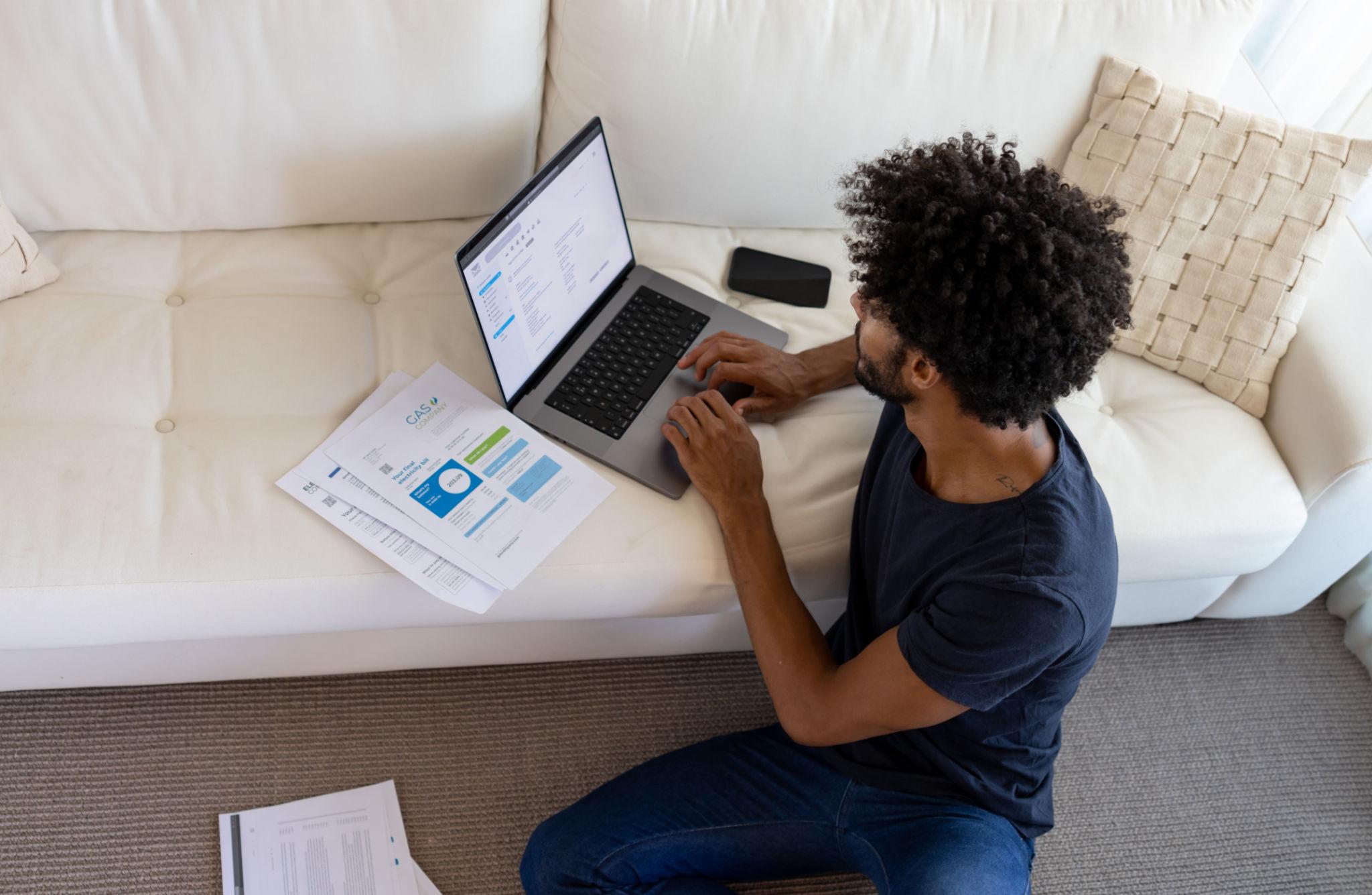 Mulher sorridente organizando contas e utilizando notebook em casa